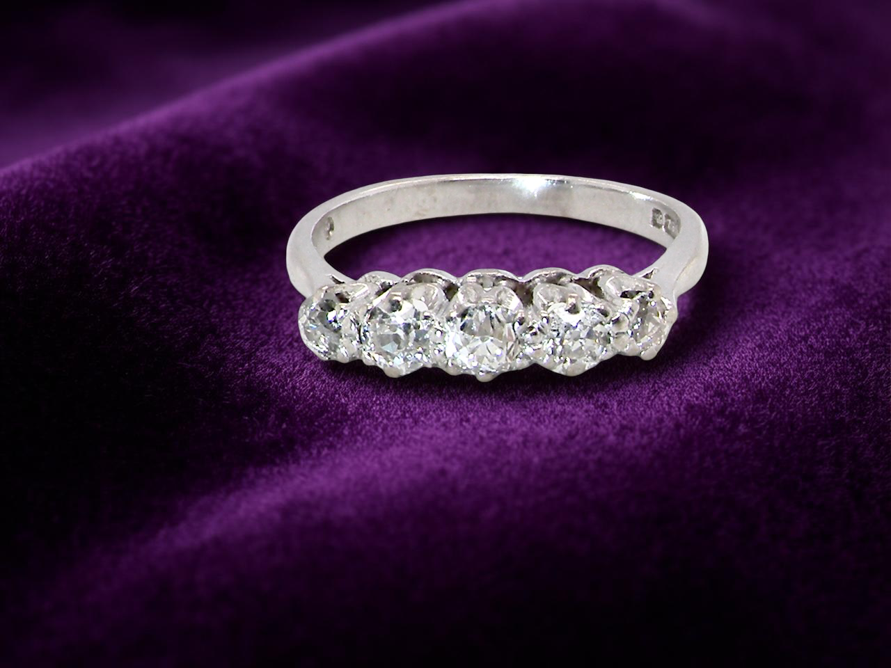 An elegant 18 carat white gold five-stone ring set with brilliant-cut white diamonds. The centre diamond measures 3.4mm, flanked by two 3.0mm stones and finished with 2.8mm diamonds at each end, creating a  balanced graduated design.