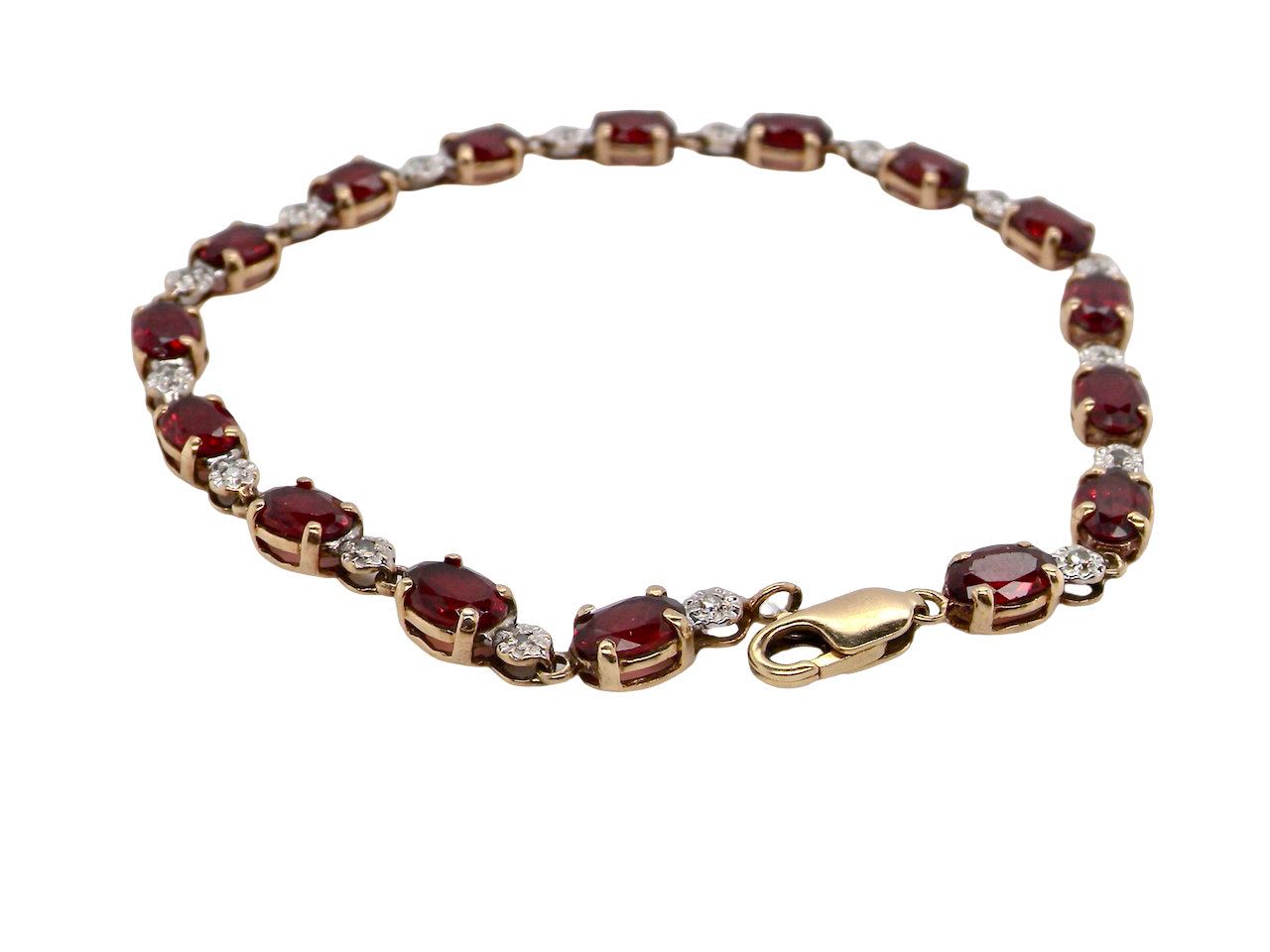 An elegant 9 carat gold bracelet set with sixteen rich red oval-cut garnets, each measuring approximately 6 x 4mm. Between each garnet sits an illusion-set diamond in white gold, creating the appearance of larger stones while adding subtle sparkle. The total diamond weight is estimated at 0.15 carats.