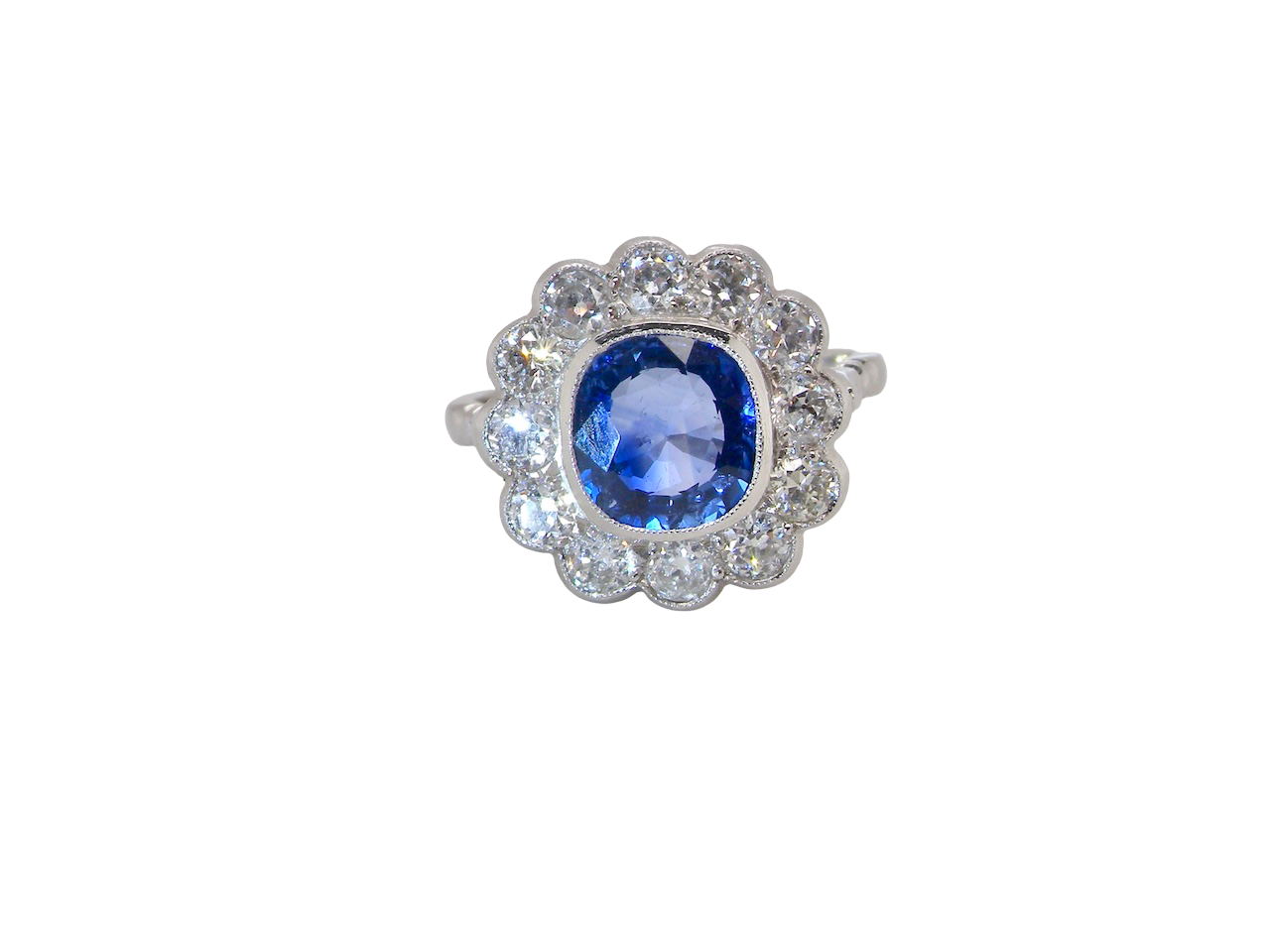 An elegant and timeless cluster ring, centrally set with a beautiful mid to deep blue cushion-cut sapphire, (estimated 2.00 carats). 