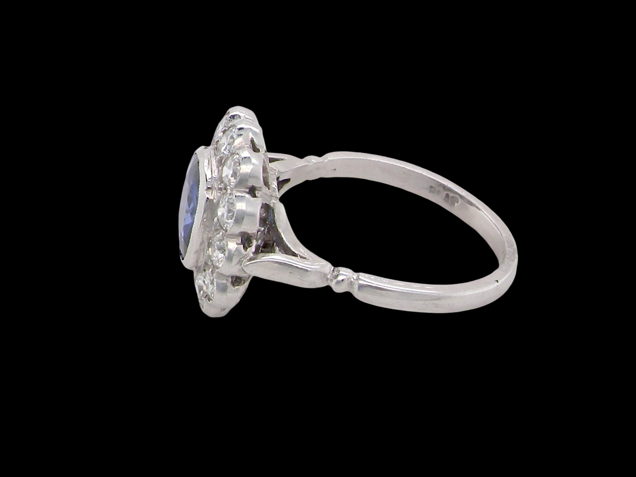 An elegant and timeless cluster ring, centrally set with a beautiful mid to deep blue cushion-cut sapphire, measuring approximately 8 x 8mm (estimated 2.00 carats).  side