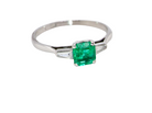 An elegant and timeless platinum ring featuring a stunning step-cut emerald to the centre, measuring approximately 5.5 x 5.5mm and estimated at 0.80 carats. The emerald displays a  deep green colour with excellent presence.