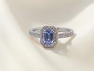 An elegant cluster ring that features to the centre a rectangular tanzanite gemstone that measures 6x4mm (est 0.50 carats) 