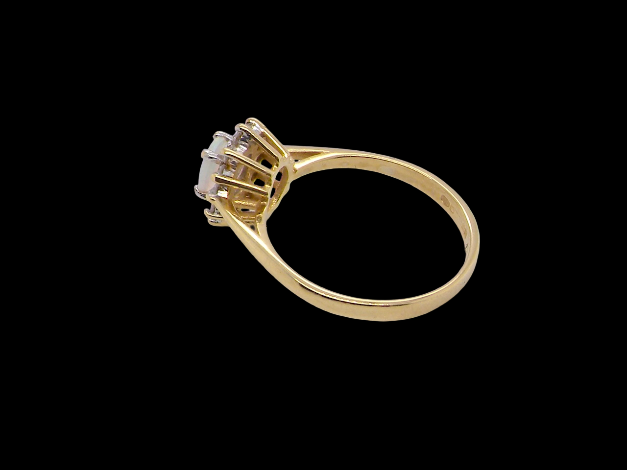An elegant&nbsp; cluster ring featuring a white opal centre stone measuring 6 × 4mm, displaying a lively and attractive play of colour. side