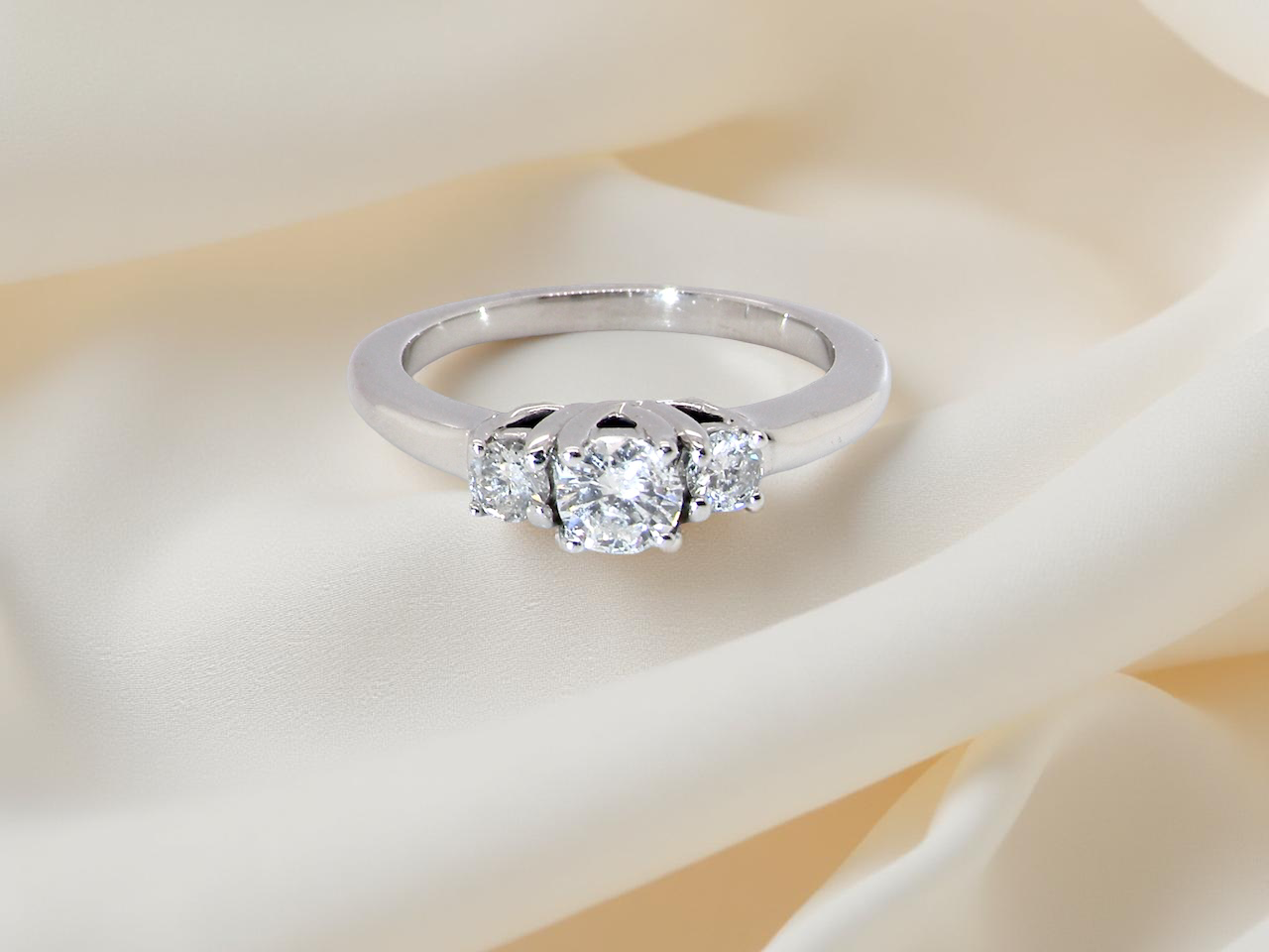 An elegant trilogy ring set with three  white diamonds, 