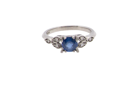 An elegant vintage-style platinum ring showcasing a beautifully proportioned round sapphire with a soft mid to light cornflower blue hue. The sapphire measures 5.6mm in diameter (approx. 0.80 carats) 