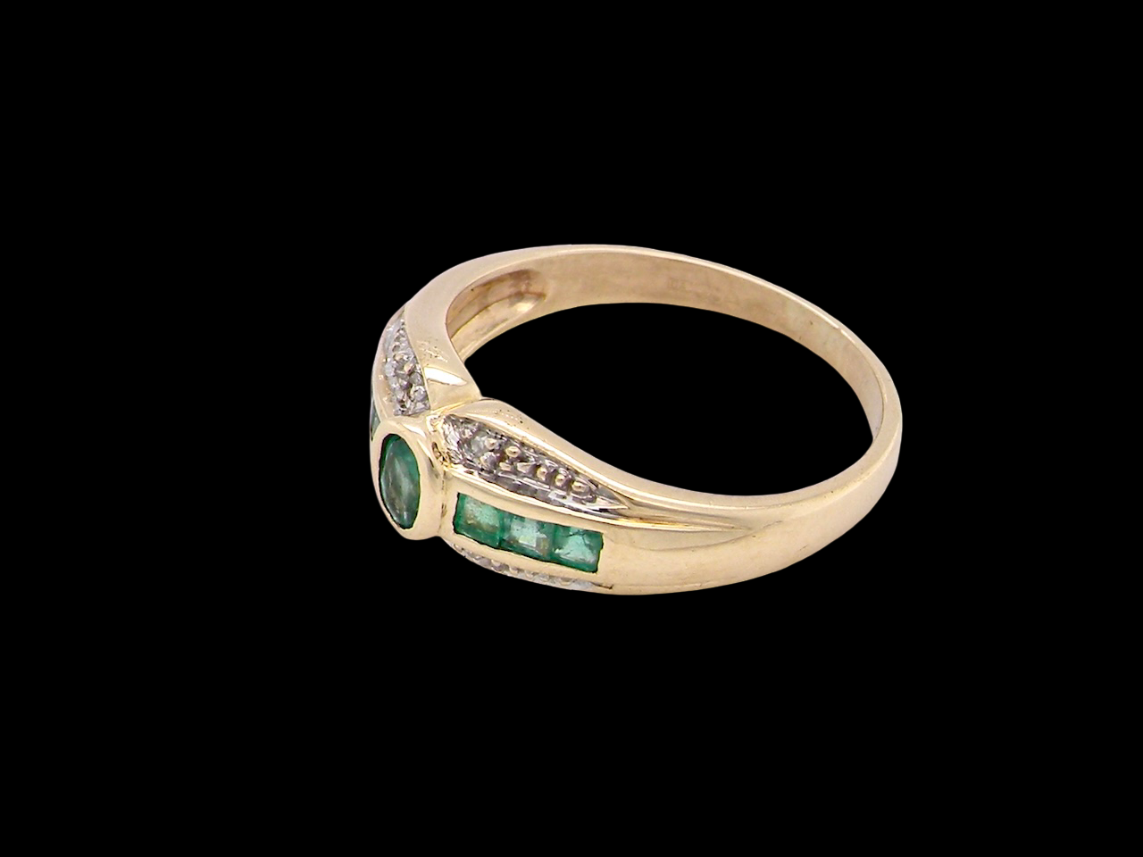 An emerald and diamond dress ring