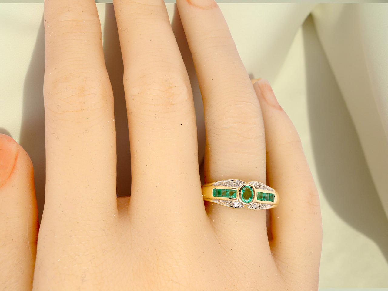 An emerald and diamond dress ring