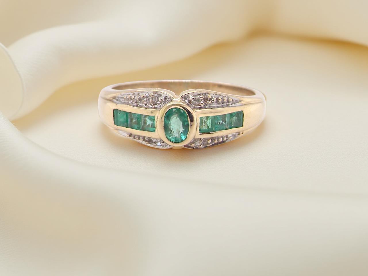 An emerald and diamond dress ring