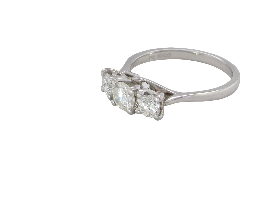 An exceptional three stone diamond trilogy ring, beautifully crafted in platinum and set with three modern brilliant cut white diamonds. side