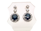 An exquisite pair of drop earrings crafted in 18 carat white gold, each set with a striking inky blue-black sapphire measuring 7.5mm in diameter.