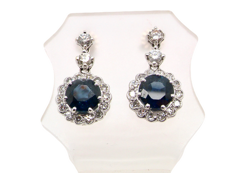 An exquisite pair of drop earrings crafted in 18 carat white gold, each set with a striking inky blue-black sapphire measuring 7.5mm in diameter.