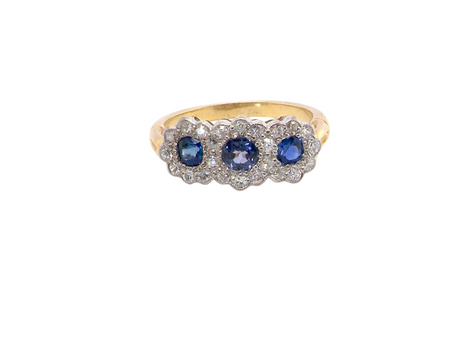 An impressive multi cluster ring. Set with three cornflower blue sapphires to each centre, 4.3mm, and each side a 3.3mm sapphire. Based on an Edwardian design
