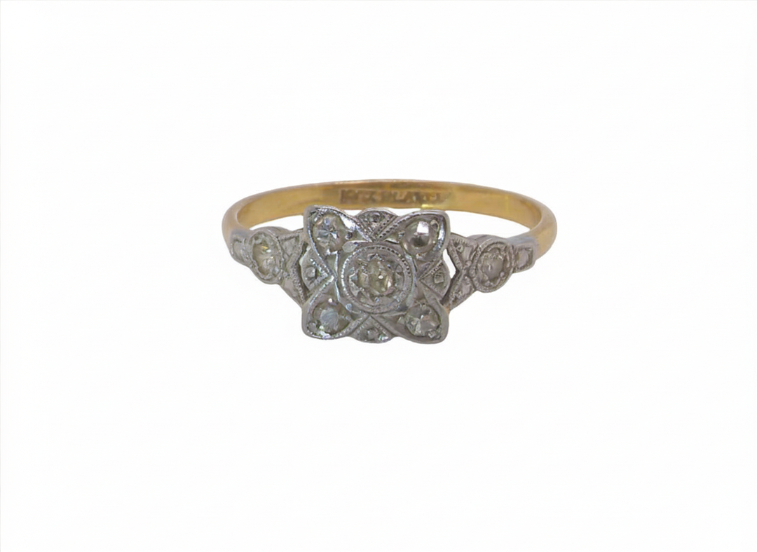 A pretty diamond cluster ring from the early part of the 20th century. A square head that has within it small white diamonds, measures 8x8mm, fancy shoulders also set with tiny diamonds.