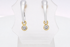 An unusual pair of earrings. The design like a French horn is fashioned in 18 carat white gold, 