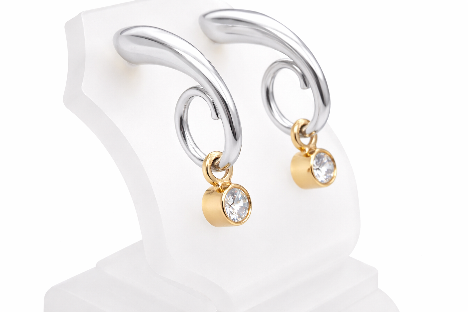 An unusual pair of earrings. The design like a French horn is fashioned in 18 carat white gold, measures 18x 10mm.