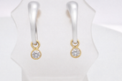 An unusual pair of earrings. The design like a French horn is fashioned in 18 carat  gold, measures 18x 10mm.