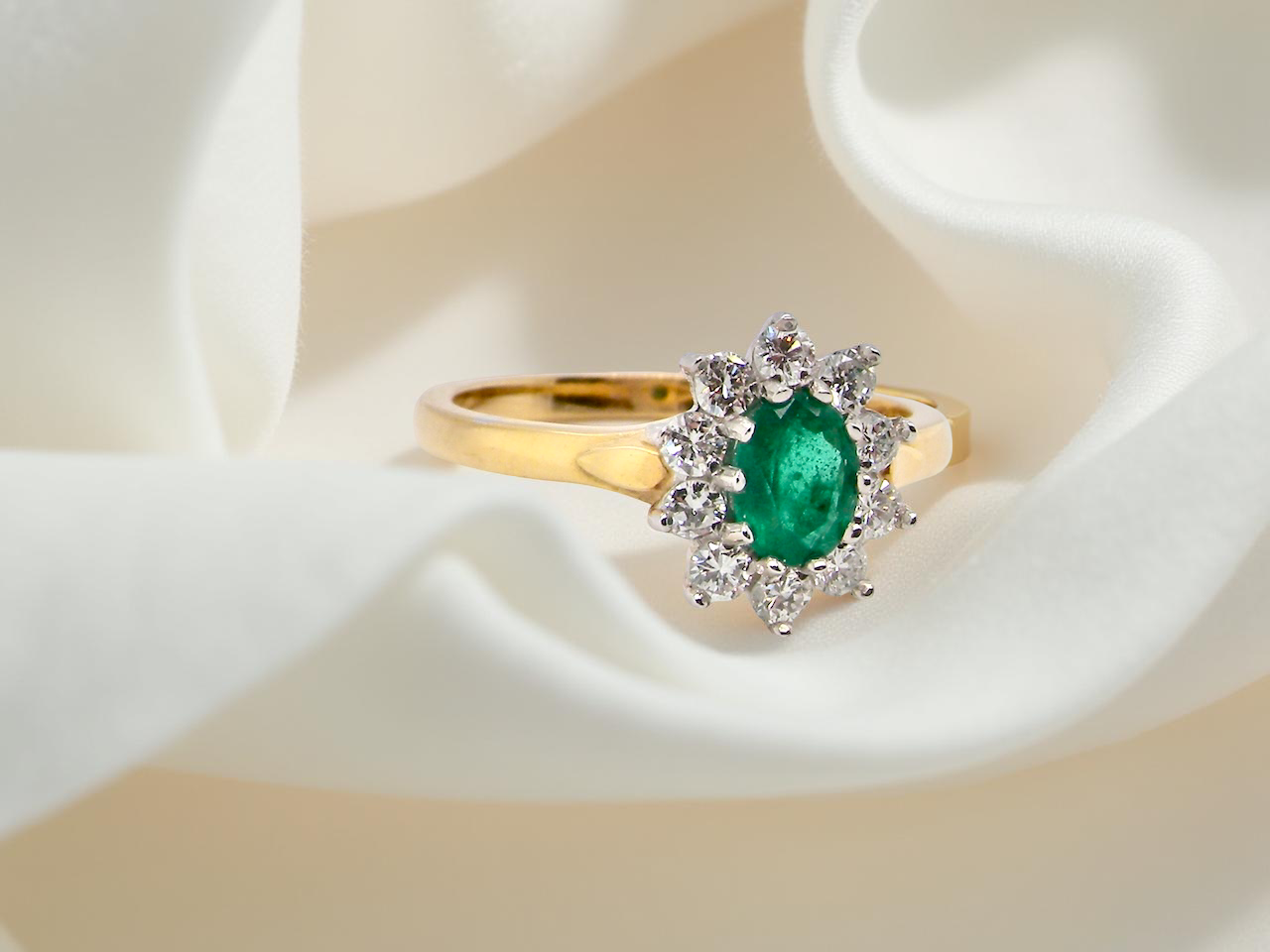 An 18 carat gold Emerald and Diamond cluster ring