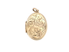 A large oval shaped locket. Measures 30x20mm. The front is hand engraved, reverse is plain.