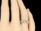 A fancy white gold foliate eternity ring