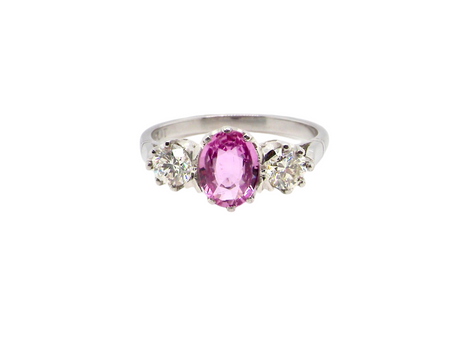 A platinum three stone pink sapphire and diamond ring