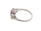 A platinum three stone pink sapphire and diamond ring side view