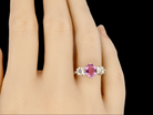 A platinum three stone pink sapphire and diamond ring finger view