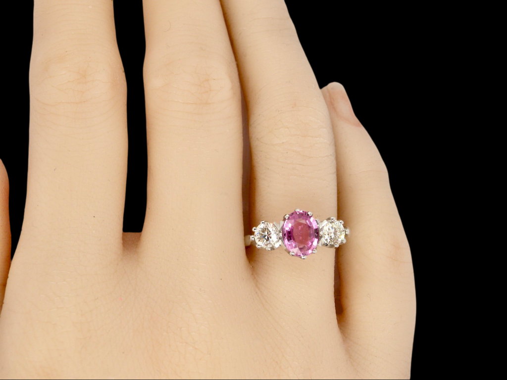 A platinum three stone pink sapphire and diamond ring finger view