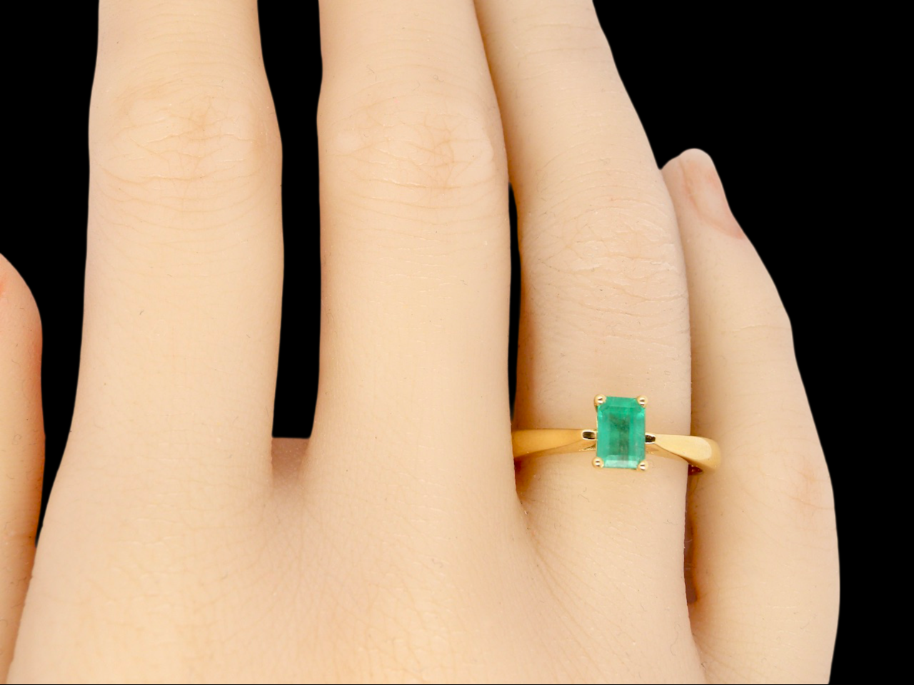 A solitaire Emerald Ring finger view