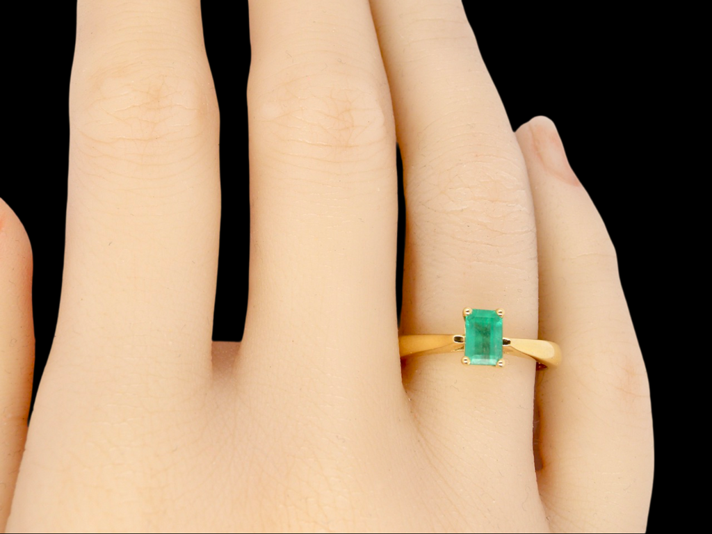 A solitaire Emerald Ring finger view