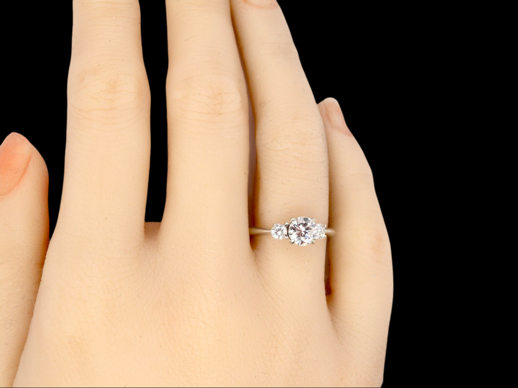 A fine three stone diamond ring finger view