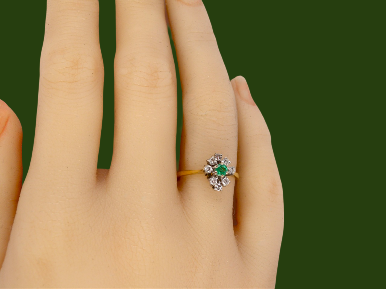 An Emerald and Diamond Cluster Ring finger view