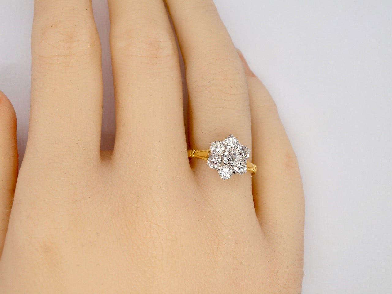 A fine traditional diamond cluster ring finger view