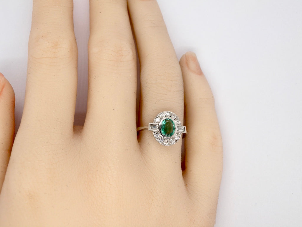 An Emerald and Diamond Cluster Ring finger view