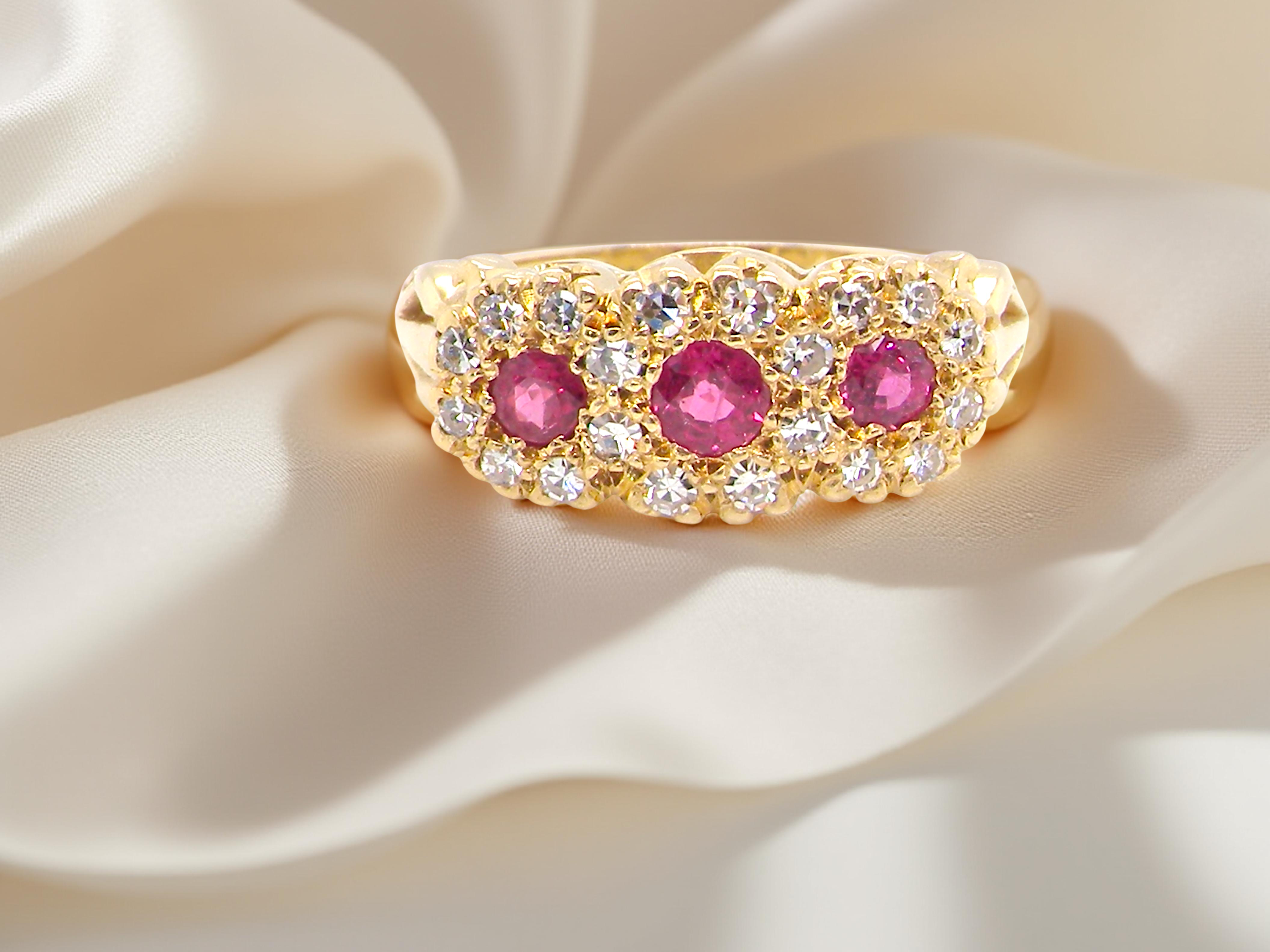 Gold ring with pink gemstones on a beige fabric background