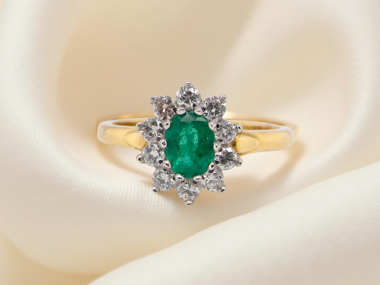 An 18 carat gold Emerald and Diamond cluster ring