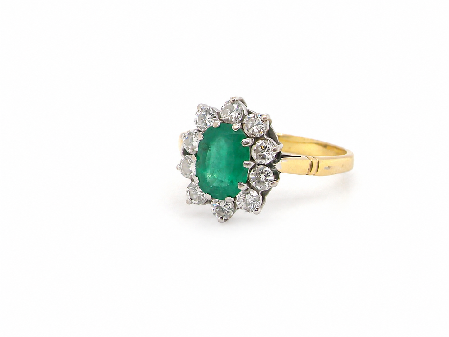 Features an oval cut emerald centre stone, vibrant green hues, measures 9x6mm(est 1.75 carats) . Complimented by an outer halo of ten 2.7mm brilliant cut white diamonds (