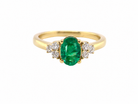 Featuring a lovely deep velvety green emerald centre stone, this 18 carat gold ring is enhanced by six brilliant cut white diamonds.
