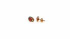 Pair of earrings with fire opals on a white background side view