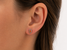 Pair of earrings with fire opals on a ear