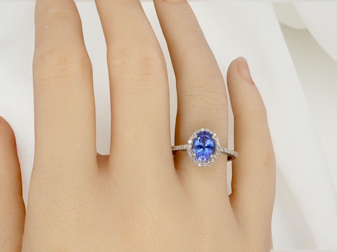 hand A fine platinum cluster ring showcasing a vibrant AAA tanzanite