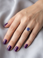 HAND A three stone ring that features an impressive tanzanite centre stone that measures 10x8mm (3.21 carats confirmed) AAA colour.&nbsp;