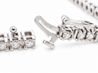 Close-up of a silver-toned tennis bracelet showing the clasp mechanism and a section of the linked chain with clear gemstones on a white background.