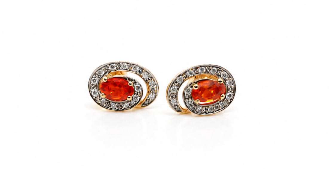 Pair of earrings with orange gemstones on a white background