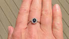 A sapphire & diamond cluster ring on a hand