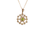 This exquisite piece features a&nbsp;6mm peridot at its centre, framed by a delicate border of fine seed pearls.
