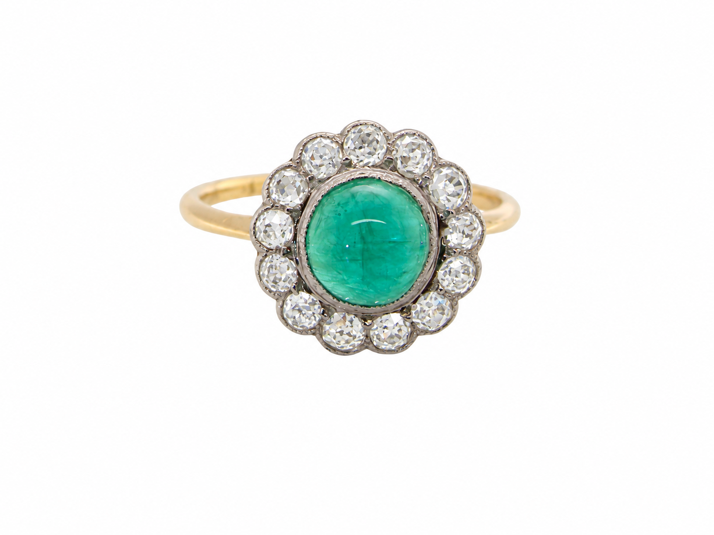 An antique cluster ring. The centre stone a cabouchon cut emerald