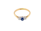 above view The classic trilogy ring, this features to the centre a round mid to dark blue sapphire and each side a brilliant cut white diamond