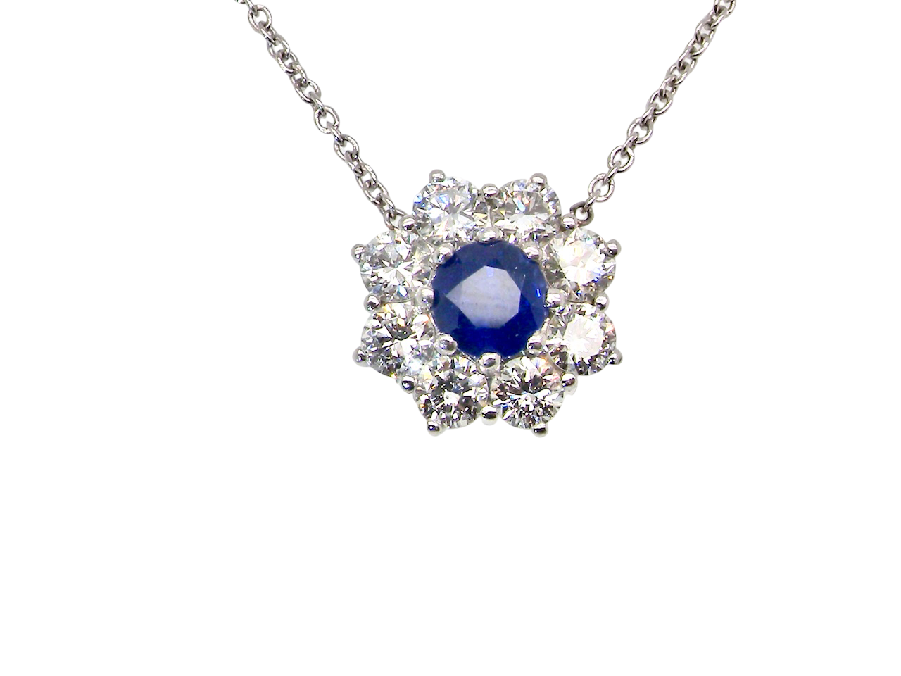beautiful new 18 carat white gold cluster pendant, showcasing a sapphire at its centre.