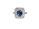 beautiful original Art Deco cluster ring featuring a dark blue oval-cut sapphire