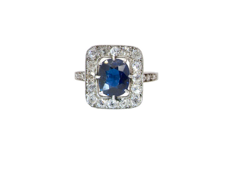 beautiful original Art Deco cluster ring featuring a dark blue oval-cut sapphire